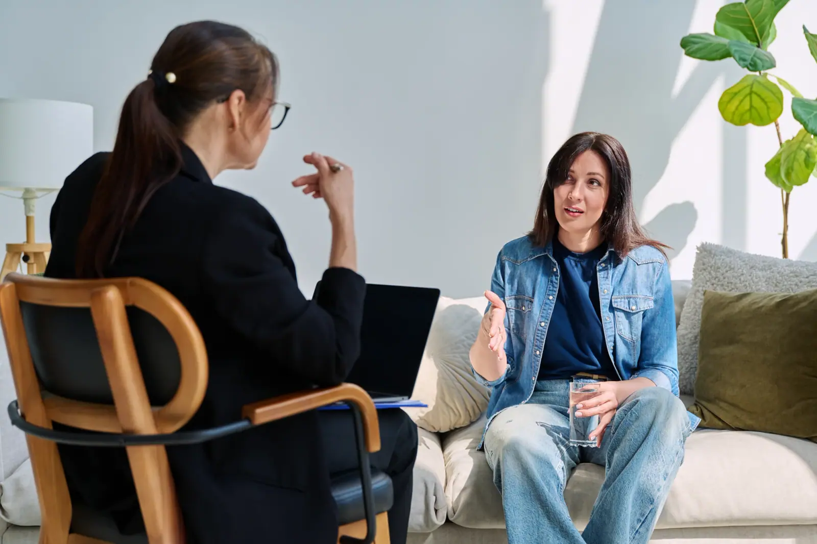 Woman in a denim shirt speaking with a counselor