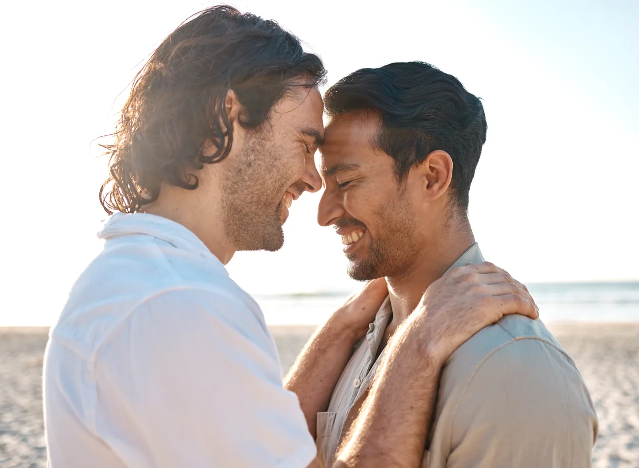 Two men embracing on a beach, representing inclusive couples treatment at Bliss Recovery
