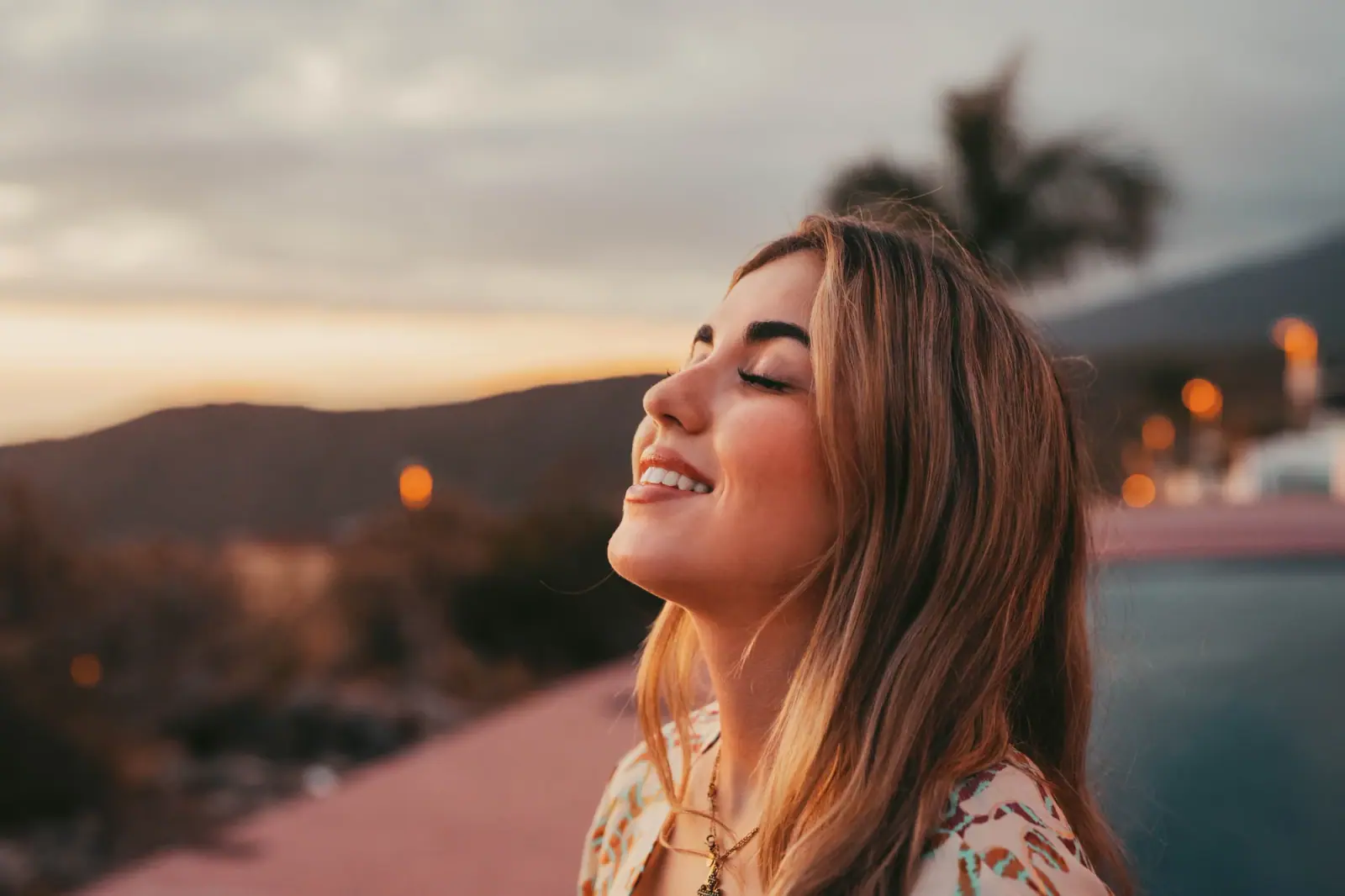 Woman relaxing outdoors at sunset, illustrating recovery for HealthSmart members