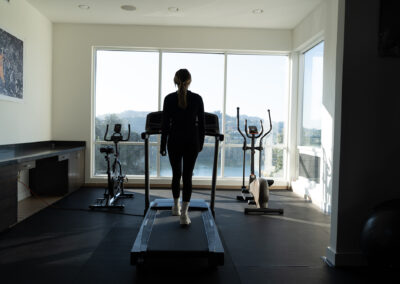 A woman exercising on a treadmill in a room at Bliss Recovery LA.