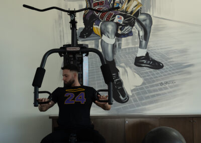 A man at Bliss Recovery LA is using a gym machine to exercise and stay fit.