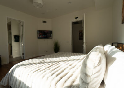 A luxurious bed with a white comforter in a room at a luxury drug rehab center in Los Angeles